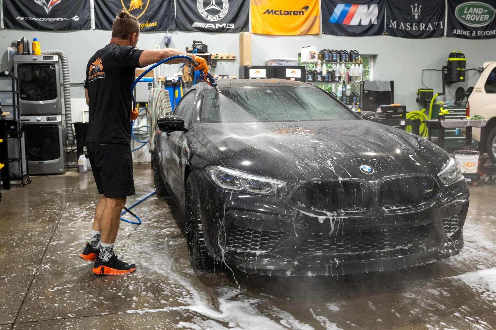Black BMW being rinsed after preservation wash